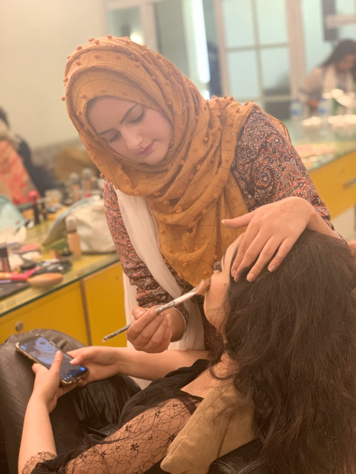Shehwar applying bridal makeup to a client